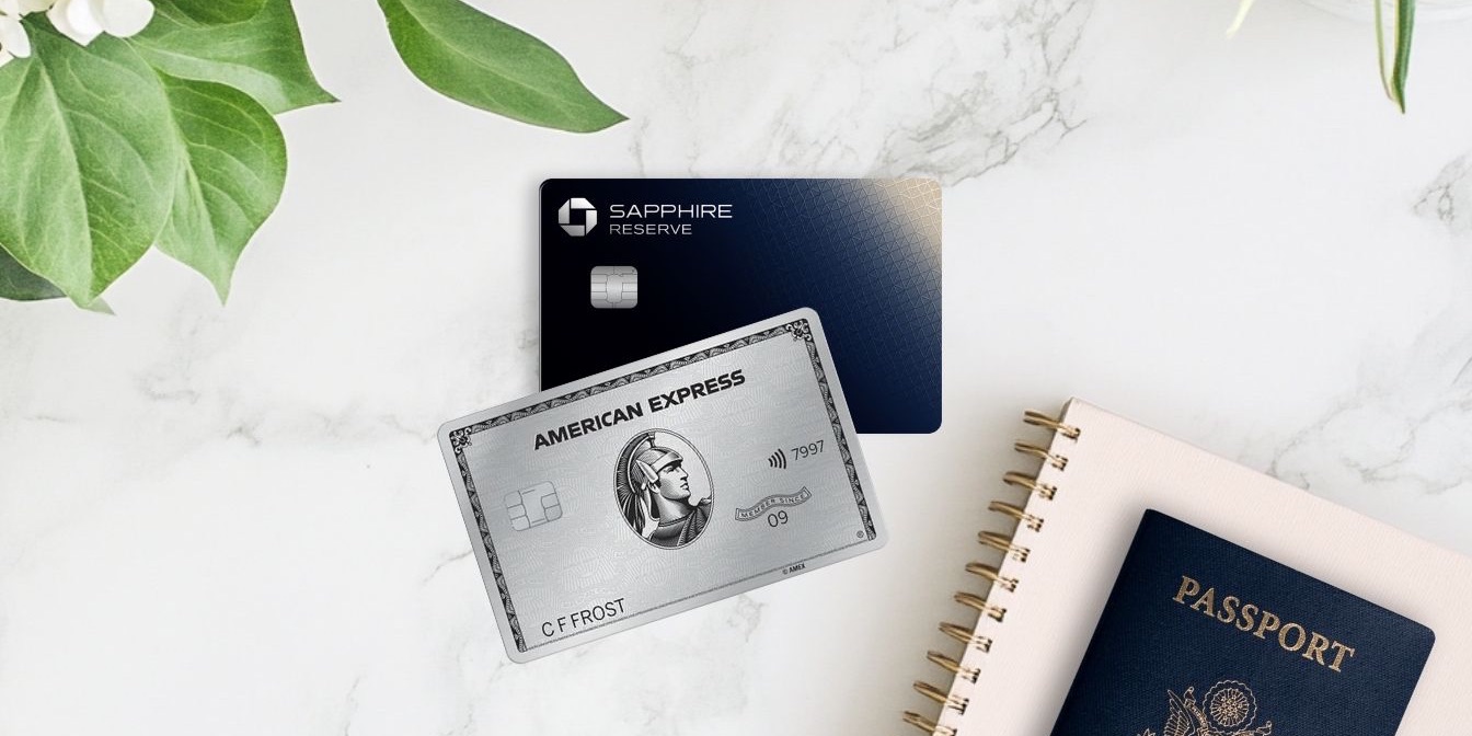 Amex Platinum and Chase Sapphire Reserve cards on a marble counter top with notebook, passport, and floral arrangement