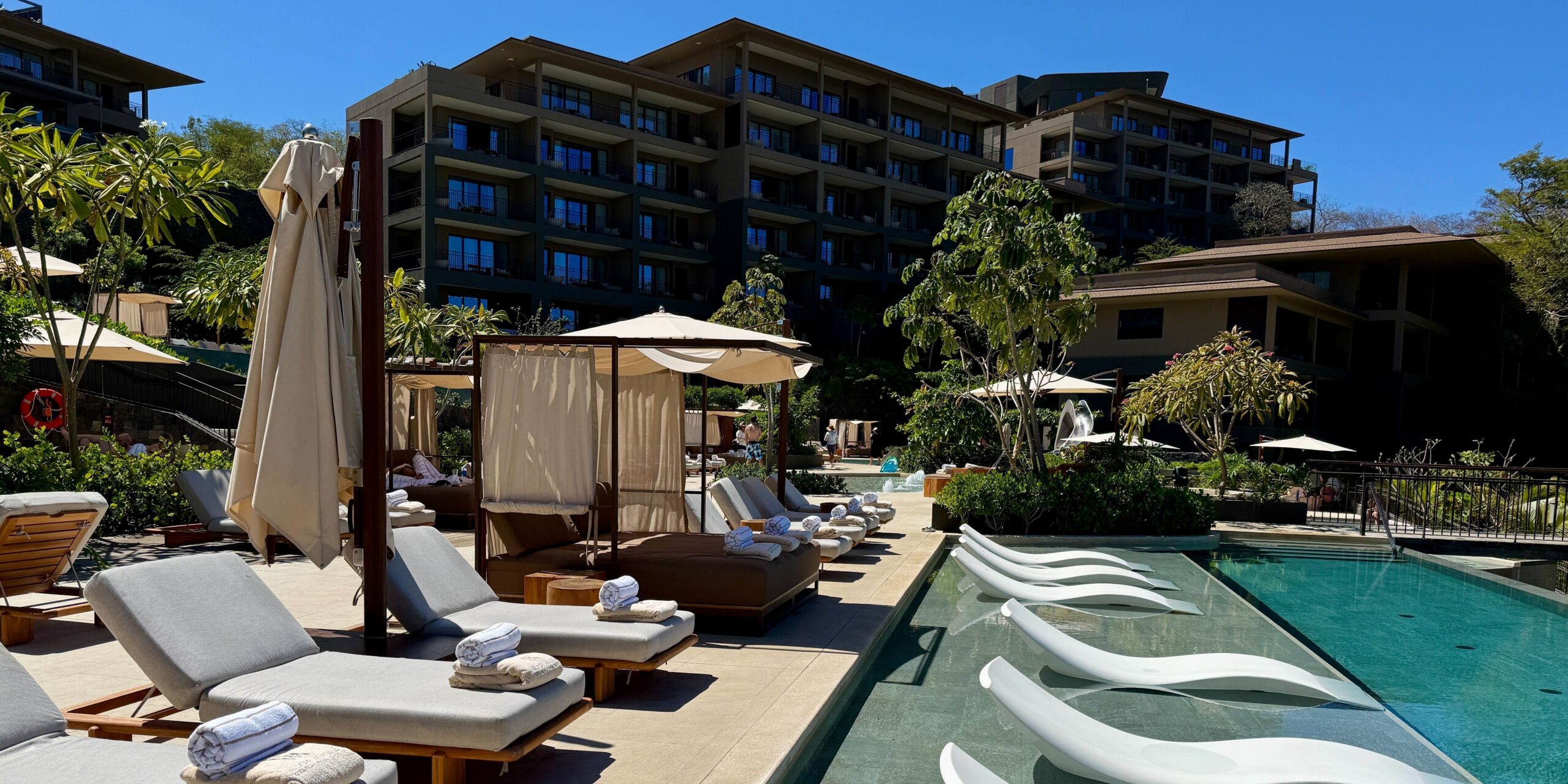 Limited-Time Offers: Earn up to 175K Points (& 1 Free Night) With a Hilton Credit Card! 5 Waldorf Astoria Cost Rica Punta Cacique pool with a cabana, lounge chairs and hotel in the background