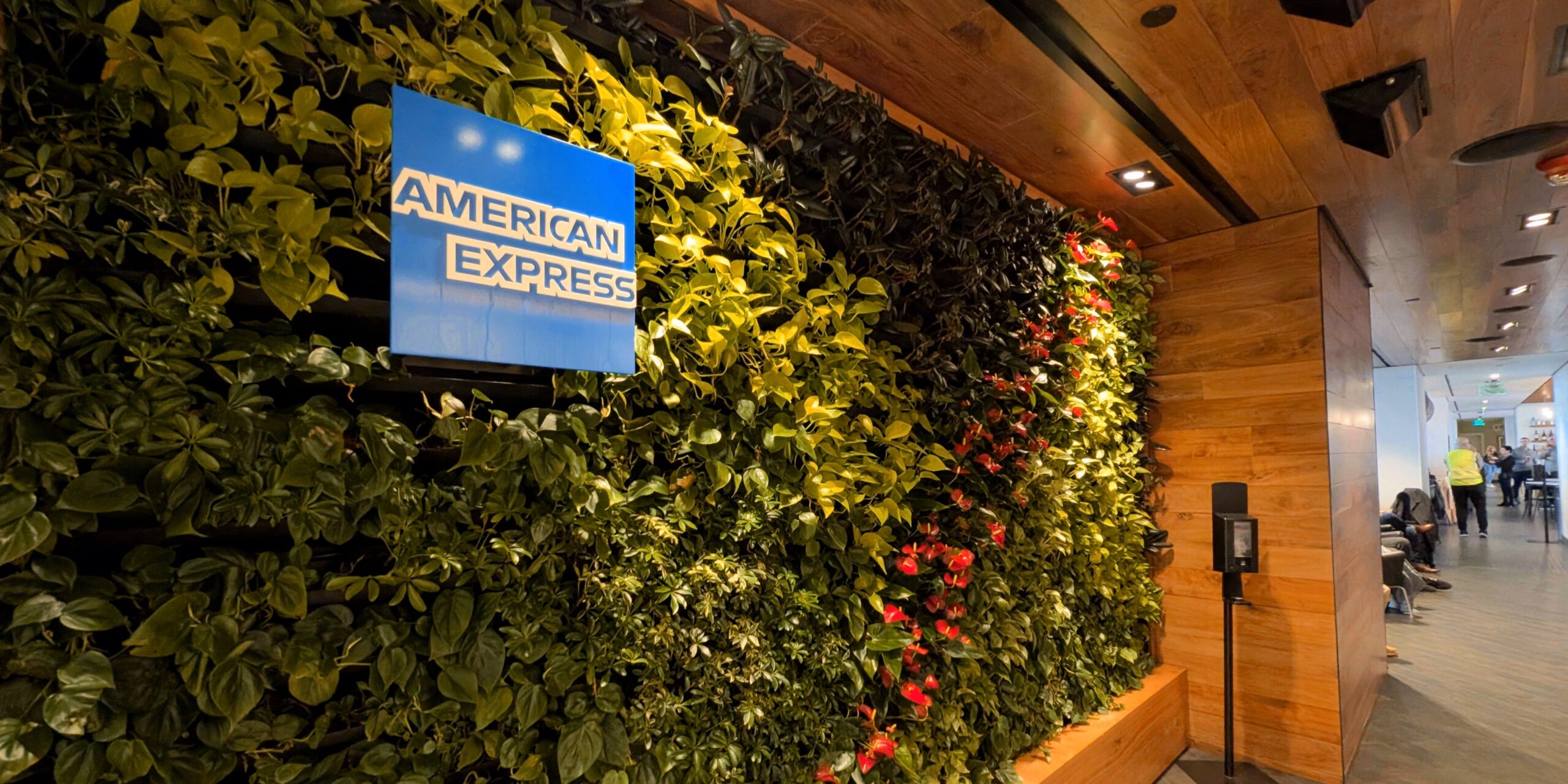 Amex Centurion Lounge (PHL) greenery on a wood-paneled wall with the Amex logo