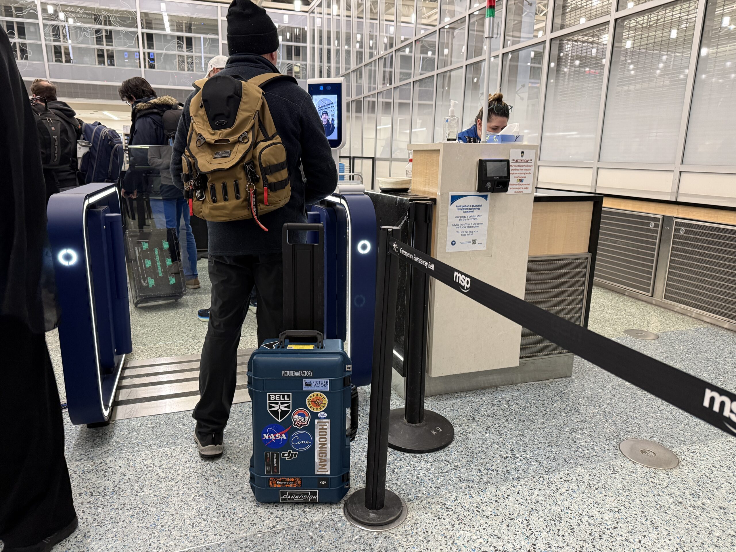 How to Check TSA Wait Times At Your Airport (& Get Through Faster) 10 man standing in front of clear e gates