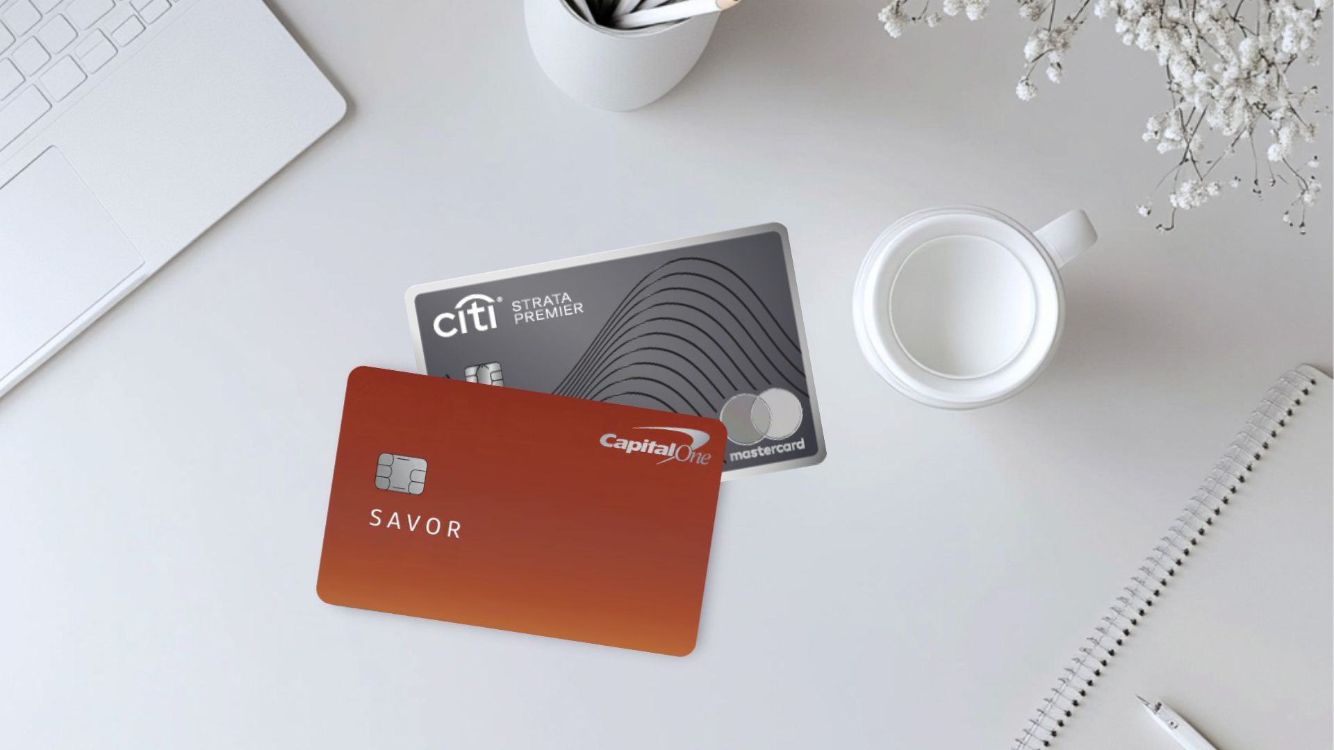 5 Questions to Ask Yourself Before Getting the American Express® Gold Card 6 Capital One Savor and Citi Premier Cards on a white table with a cup of coffee, laptop, and pens