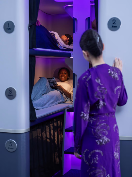 Flying Soon: Bunk Beds for Economy Flyers on Air New Zealand 2 new zealand skynest with flight attendant standing outside