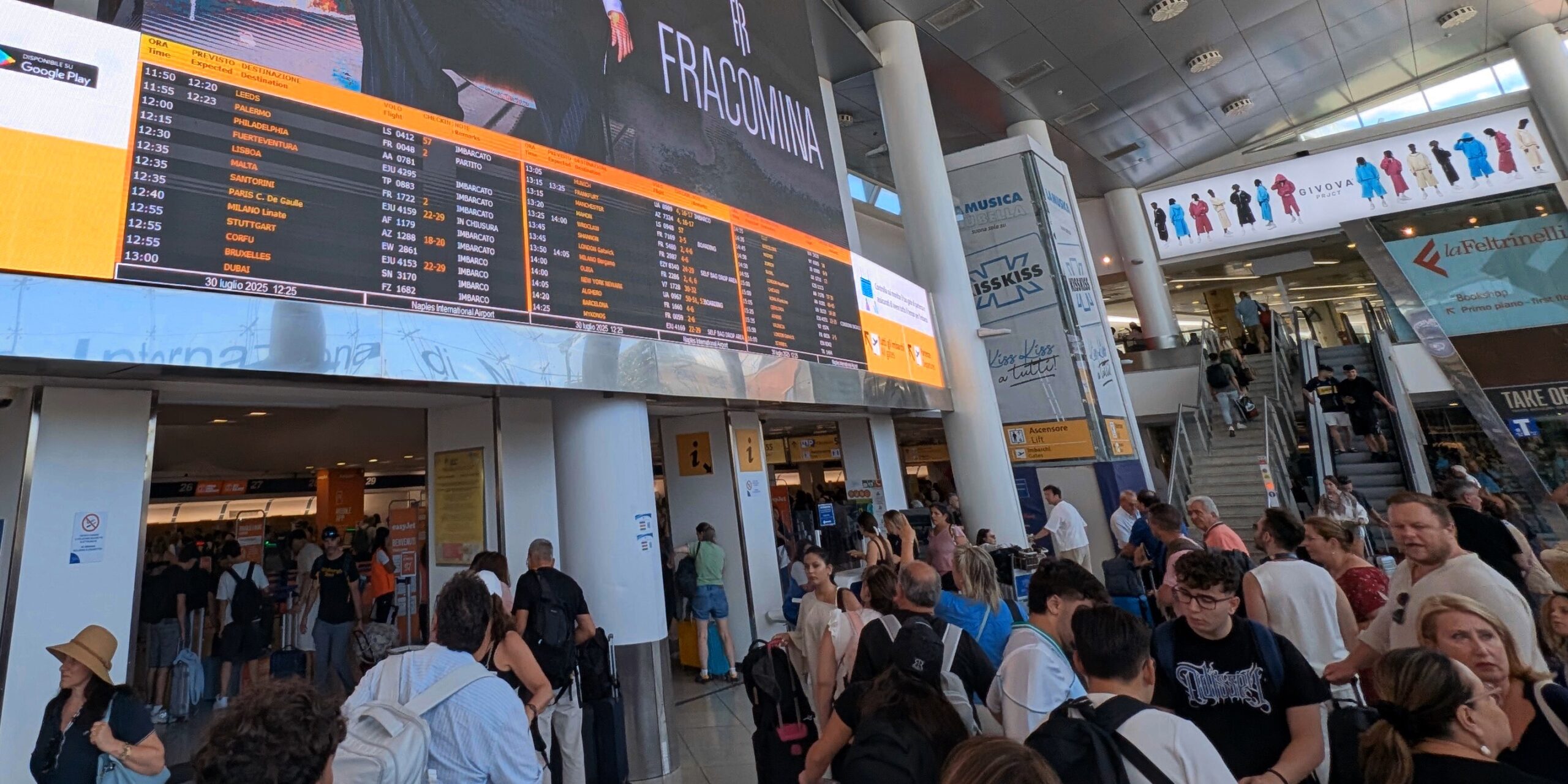 Europe’s New Border System (EES) Is Causing Delays Ahead of Busy Summer Travel Season 2 Departure board and crowds in Naples (NAP)