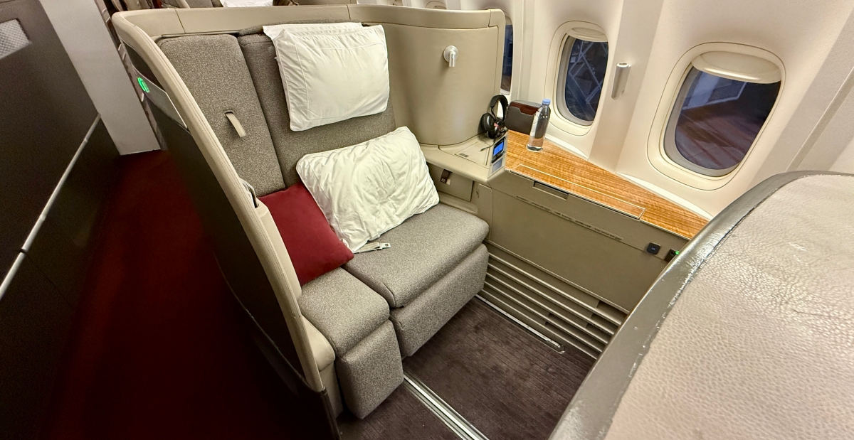cathay pacific first class seat with pillows on it