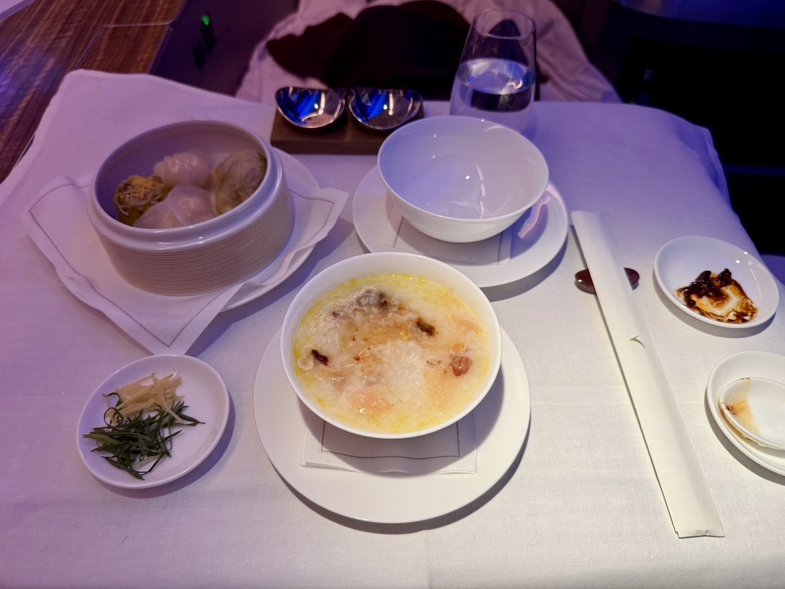 Aging Like a Fine Wine: Cathay Pacific First Class 777 Review 38 bowl of congee porridge with chopsticks and greens to the side