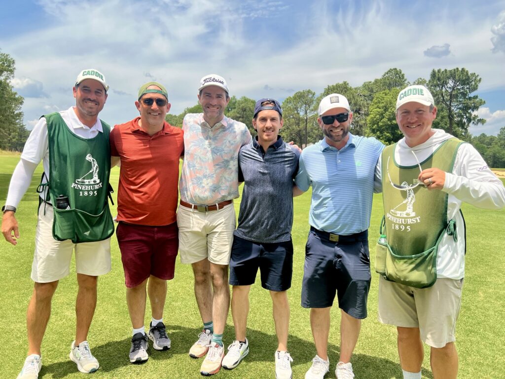7 Money-Saving Tips for a Pinehurst Golf Trip 6 4 golfers posing for a photo with 2 caddies at Pinehurst resort