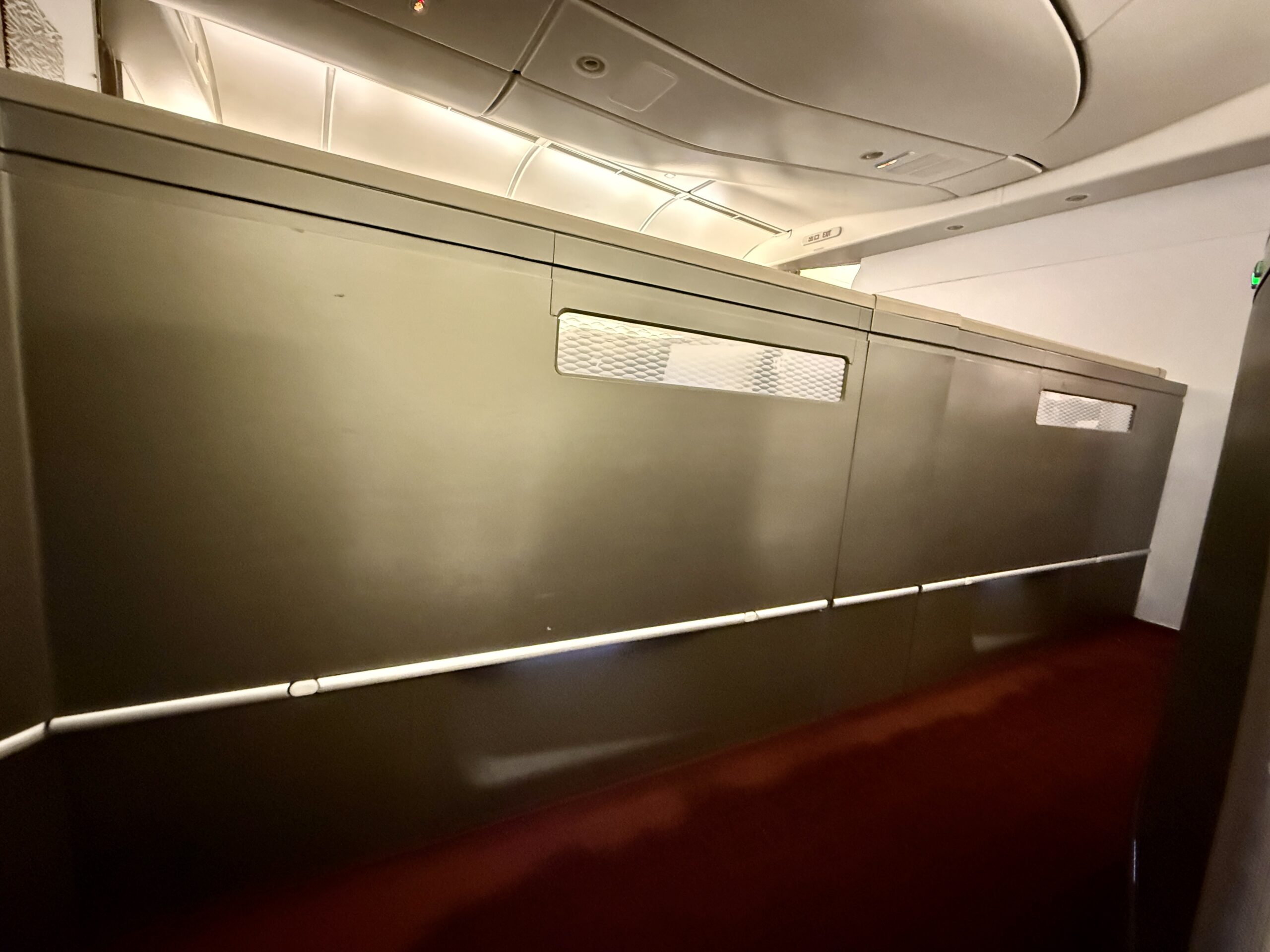 Aging Like a Fine Wine: Cathay Pacific First Class 777 Review 13 large gray wall on plane with red carpet