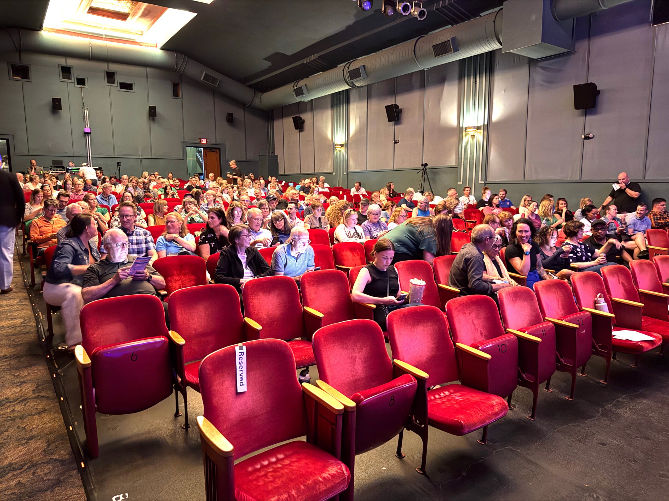 Recapping Our Live Podcast: Travelers Pack the Parkway for Hot Takes & Humiliation 1 people sitting in red theater seats
