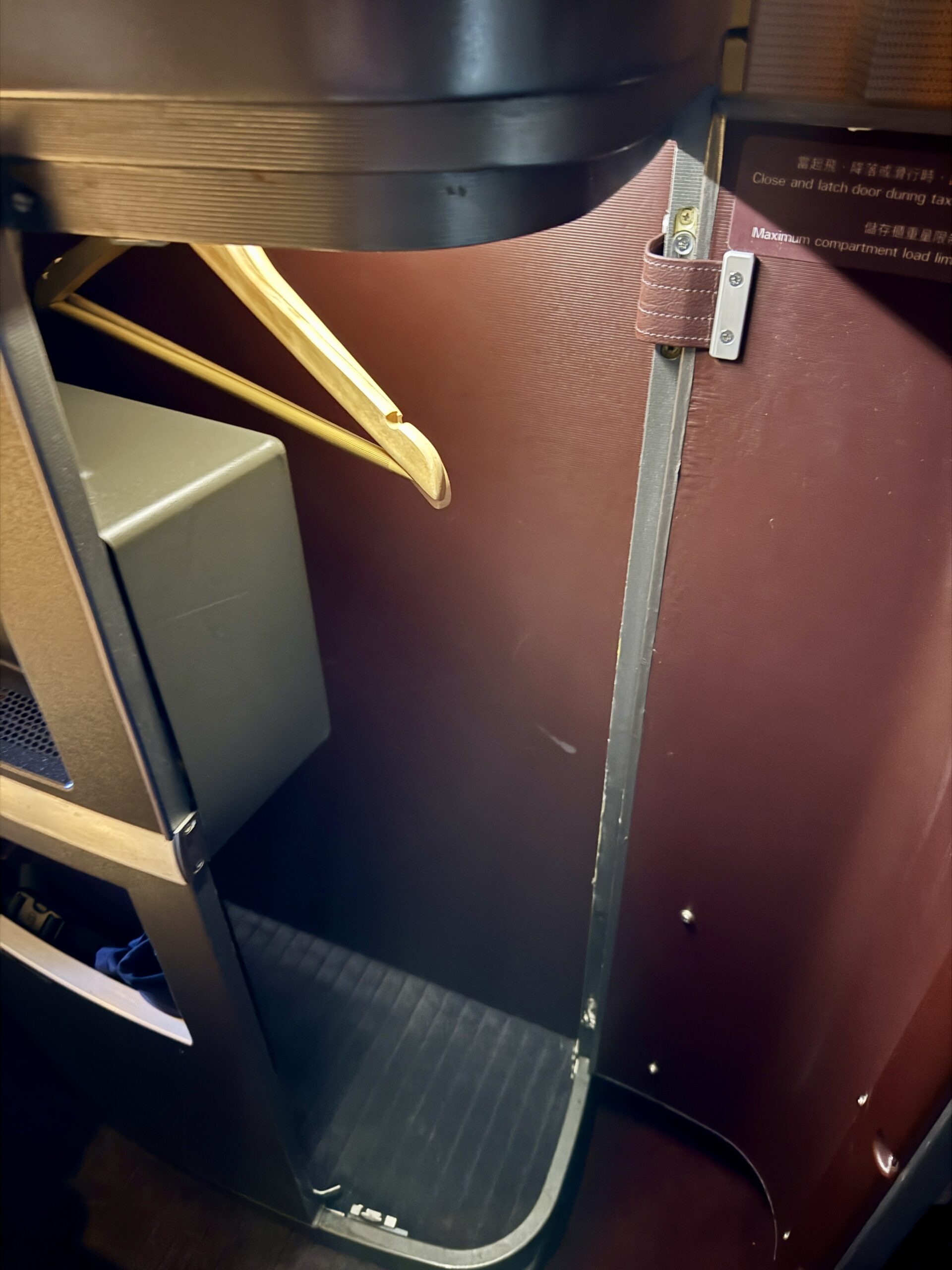 Aging Like a Fine Wine: Cathay Pacific First Class 777 Review 19 red storage closet with a hanger inside