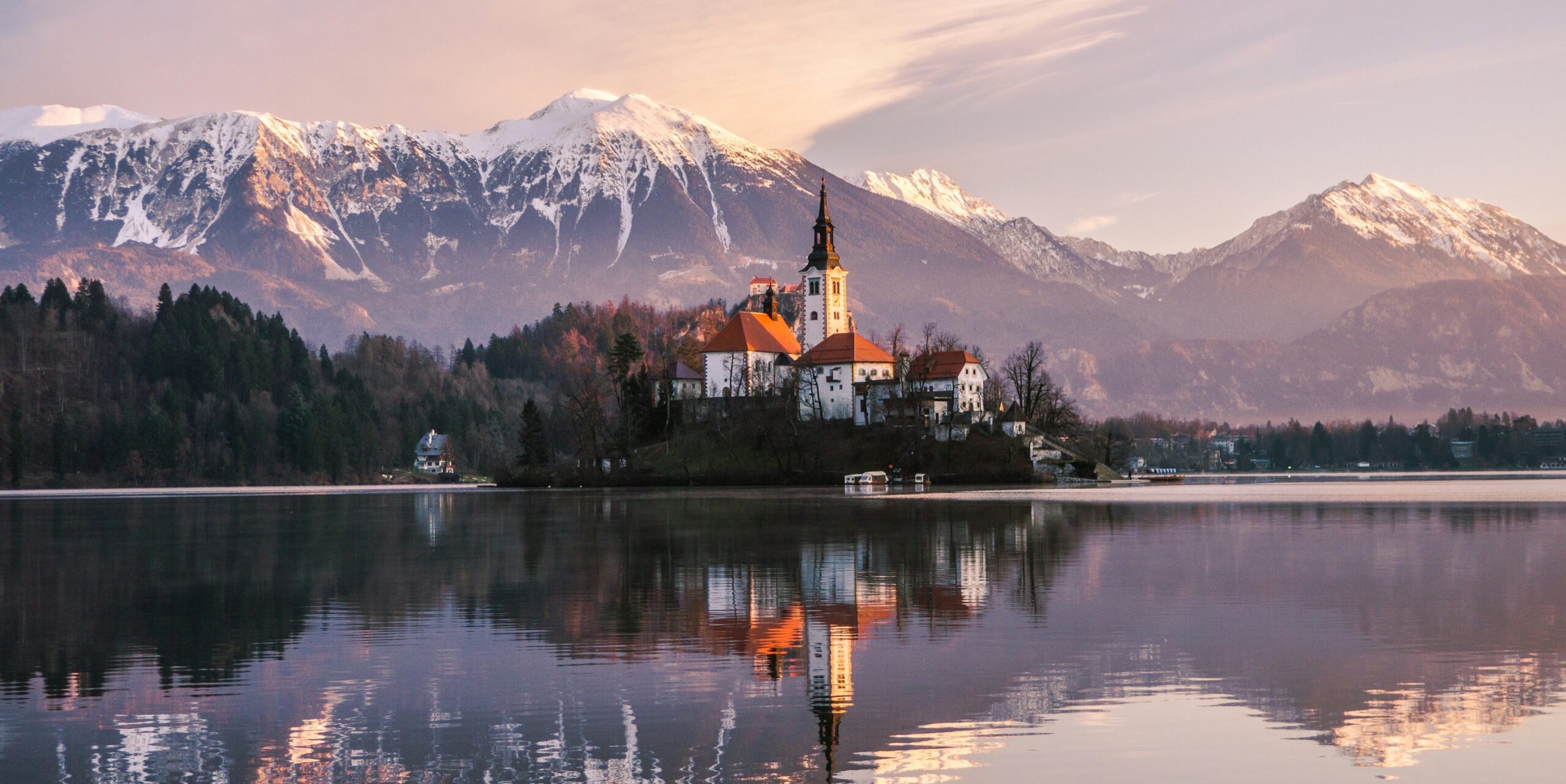 lake bled in slovenia with church reflecting in water and mountains in background