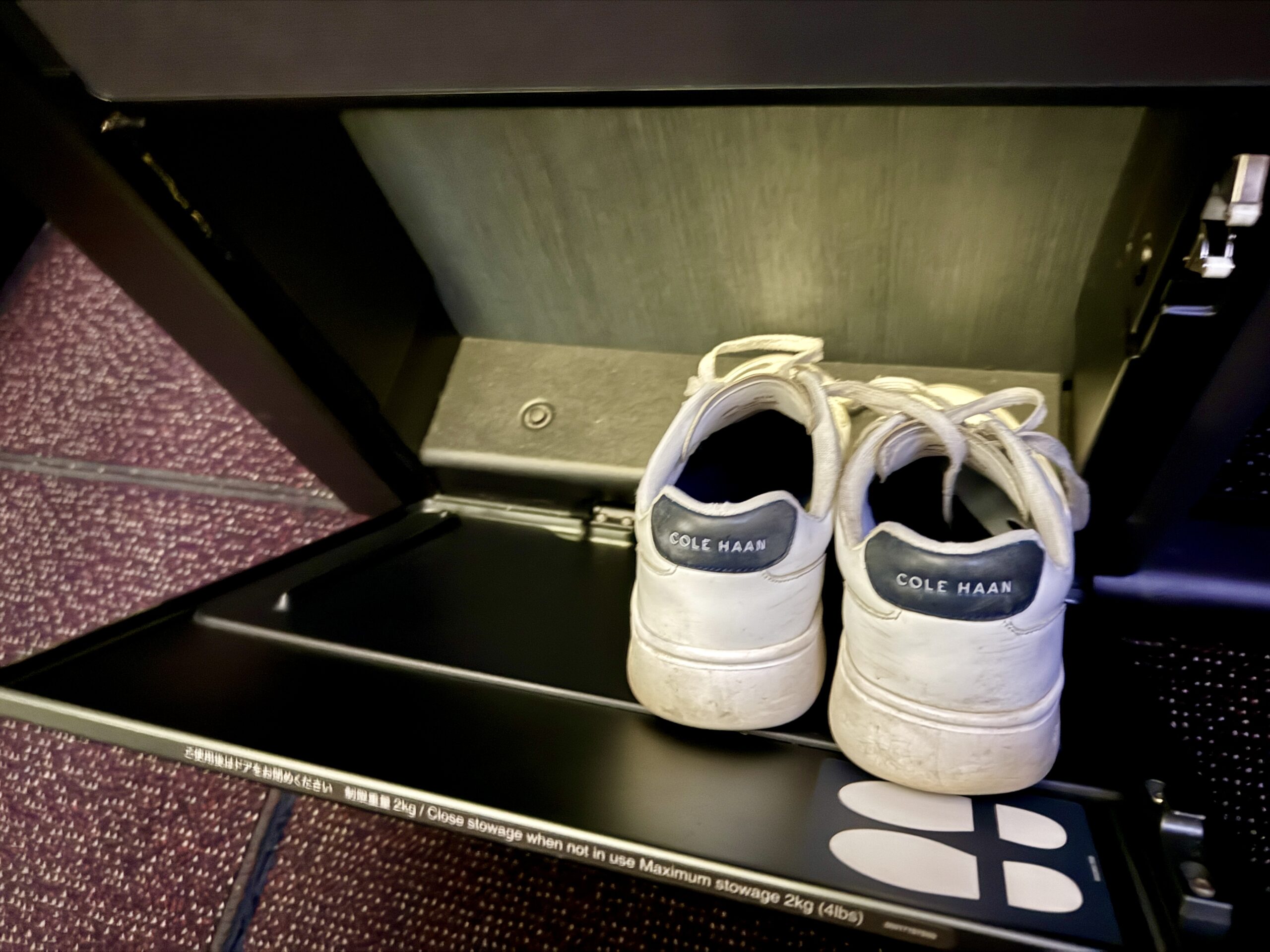 A 5-Star Flight to Tokyo: JAL's New A350 Business Class Suites 58 shoes inside of small compartment with magenta carpet