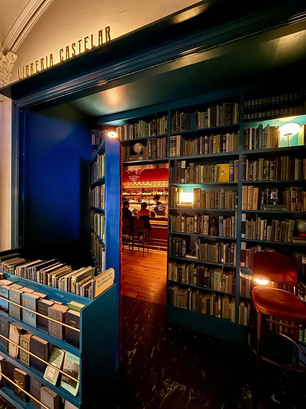 The Extra Mile, Oct. 29: Decoding Bilt's Big Changes + Mexico City Must Eats 10 A blue book-lined interior opens onto a warmly lit bar with seated people.